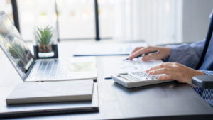 資料を見ながら電卓を打つ人の手元画像